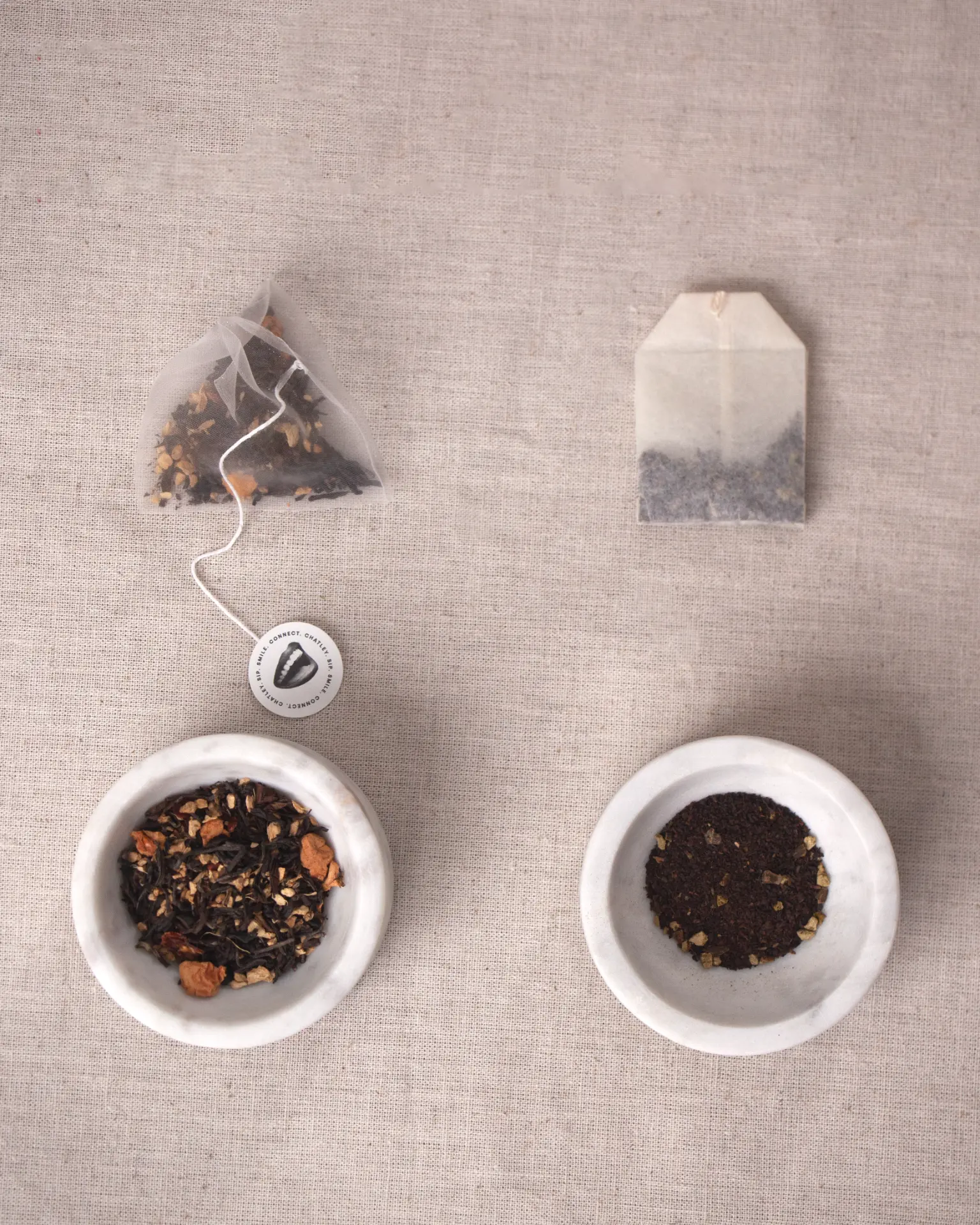 Chatley whole-leaf tea sachet and loose leaf next to an ordinary tea bag and tea dust